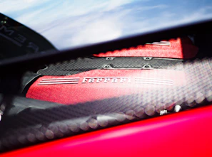 Artistic angle of a Ferrari engine component with vibrant red accents, highlighting craftsmanship.