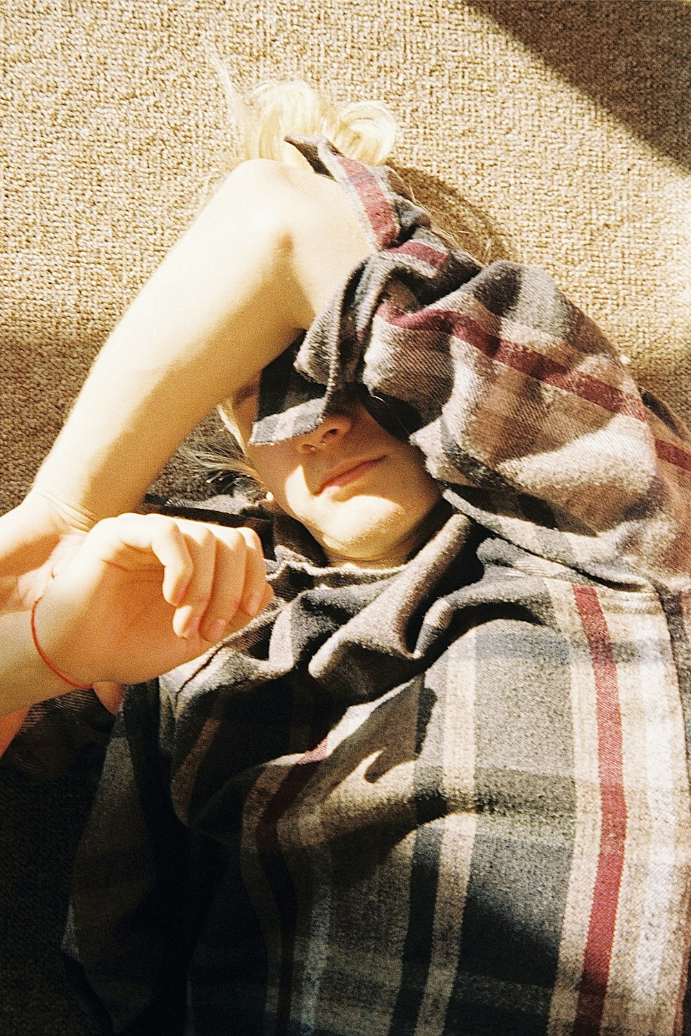 a little girl laying on top of a bed under a blanket