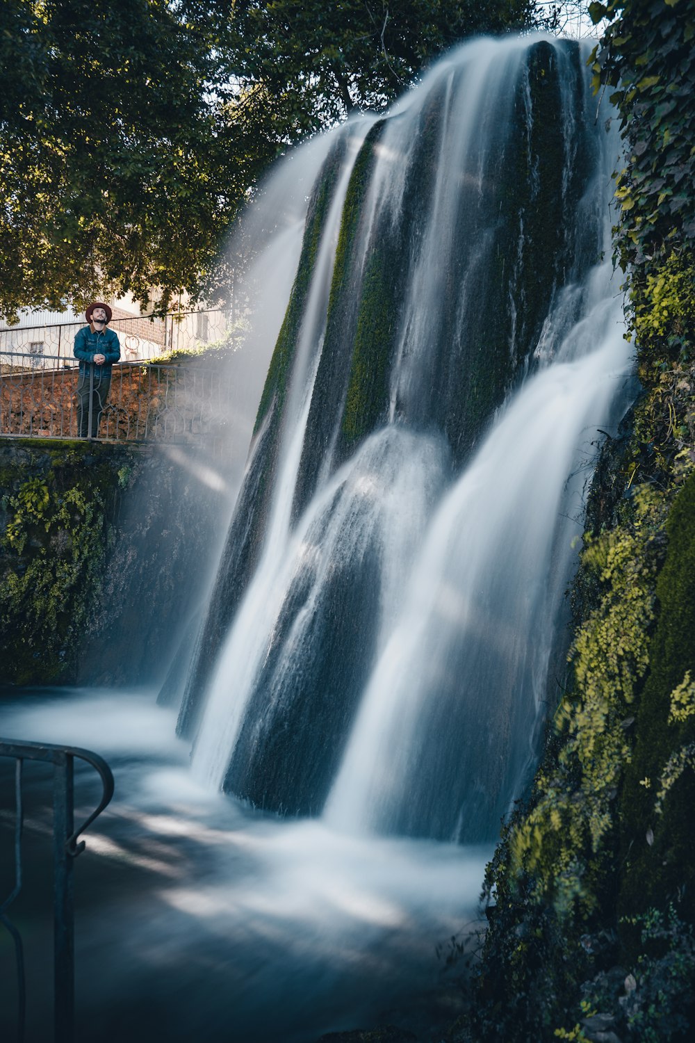 a man standing in front of a waterfall