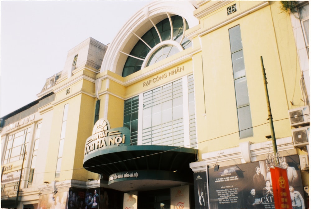 a large yellow building with a green awning