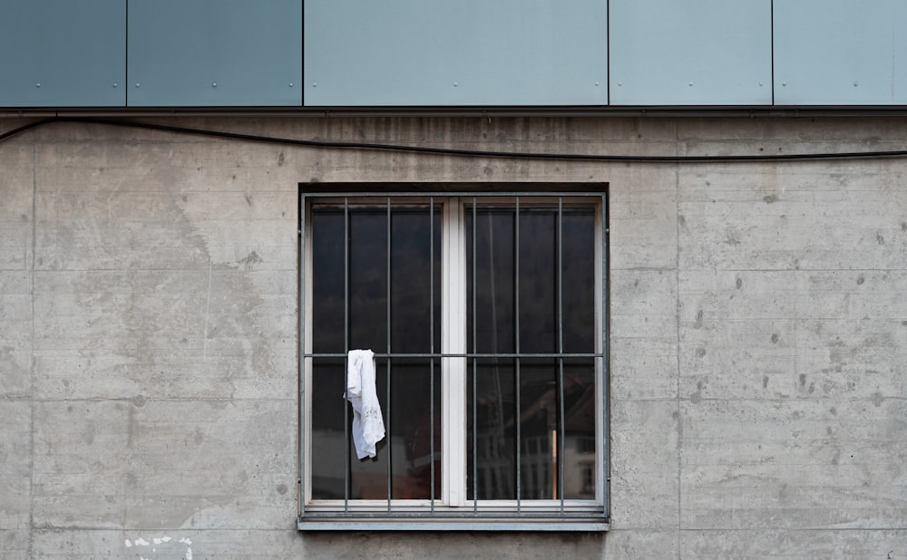 a window with bars and a towel hanging out of it