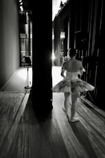 a woman in a ballet outfit is standing on a wooden floor