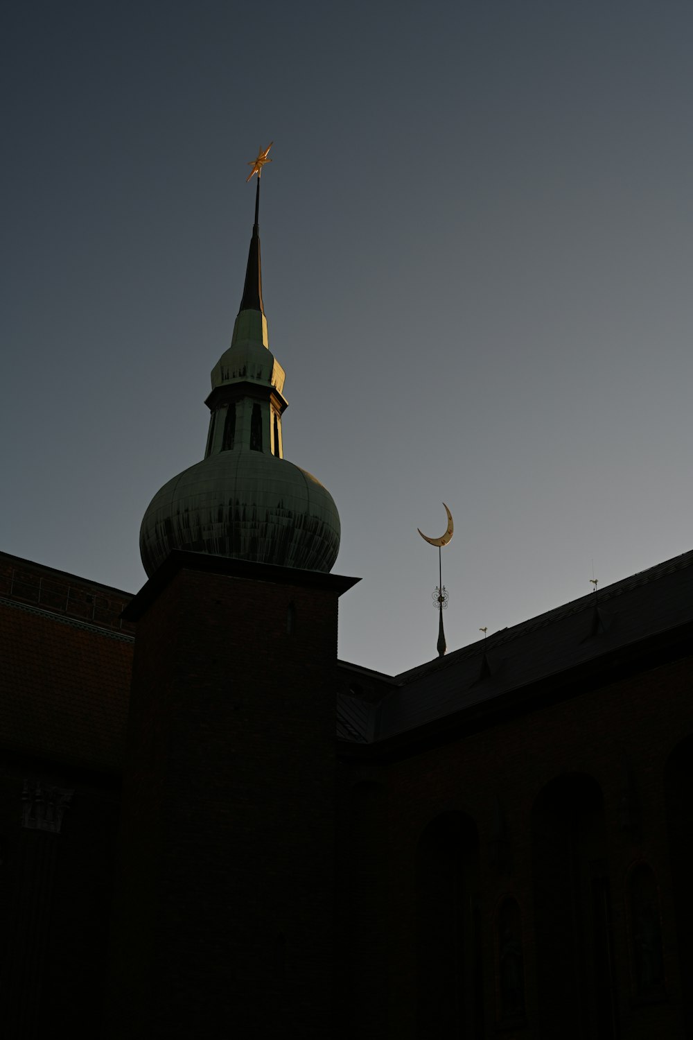 a building with a steeple and a crescent moon