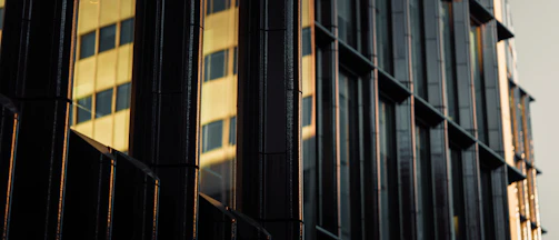 Close-up of the glass façade reflecting sunlight, highlighting the building’s modern design.
