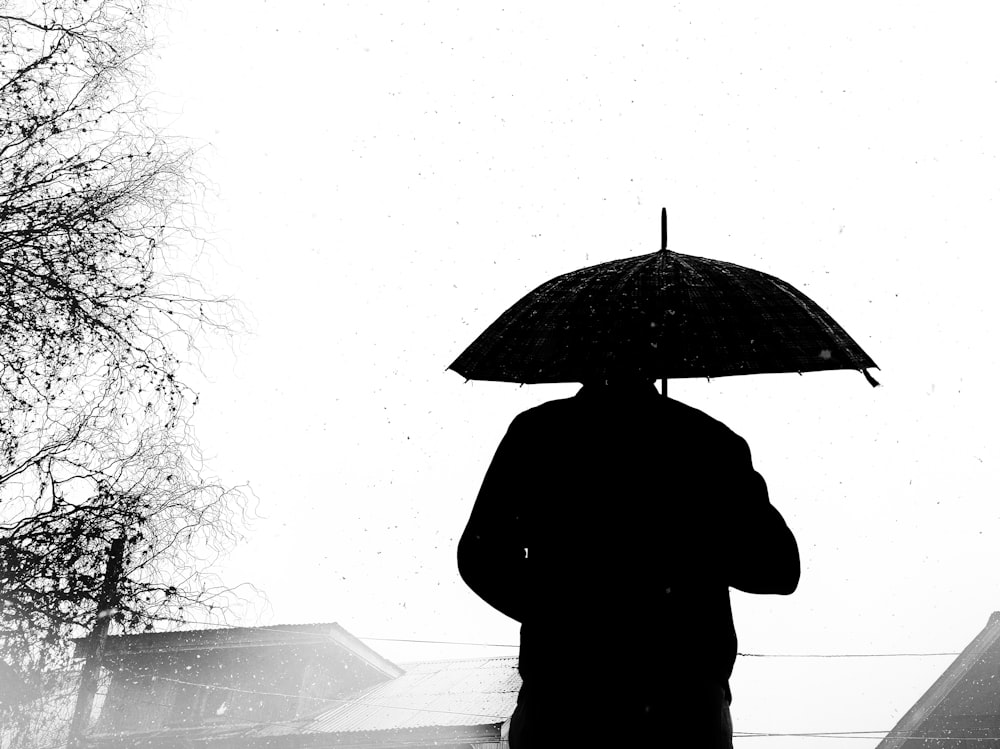 Foto Una persona caminando bajo la lluvia con un paraguas – Imagen Paraguas  gratis en Unsplash