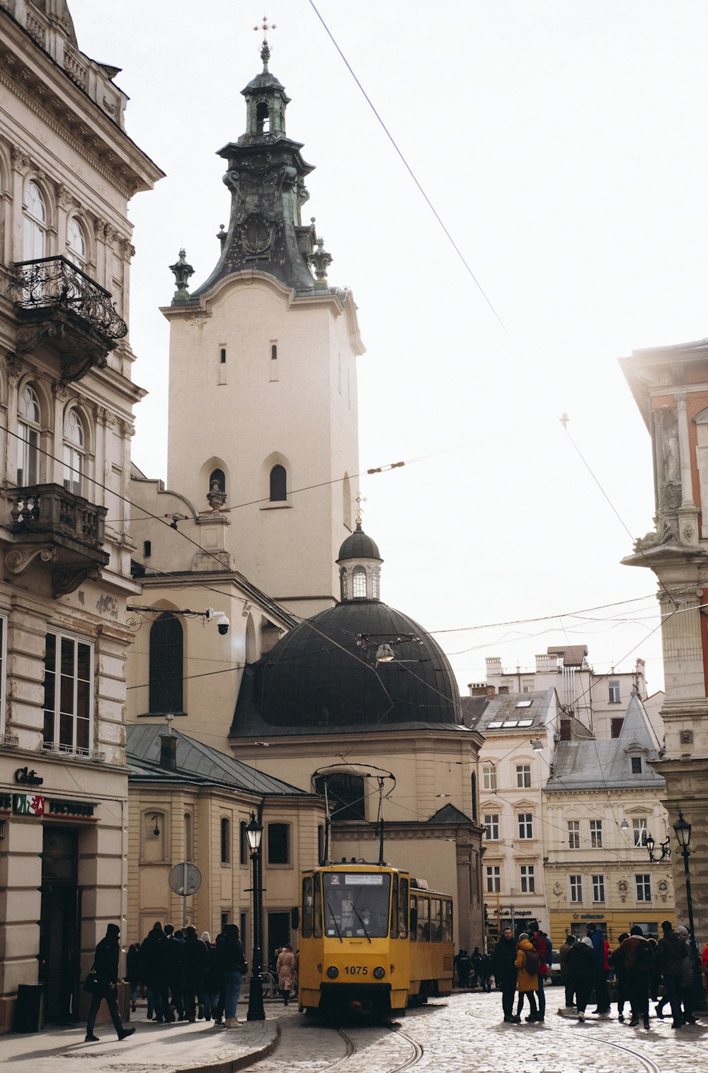 a yellow bus driving down a street next to tall buildings