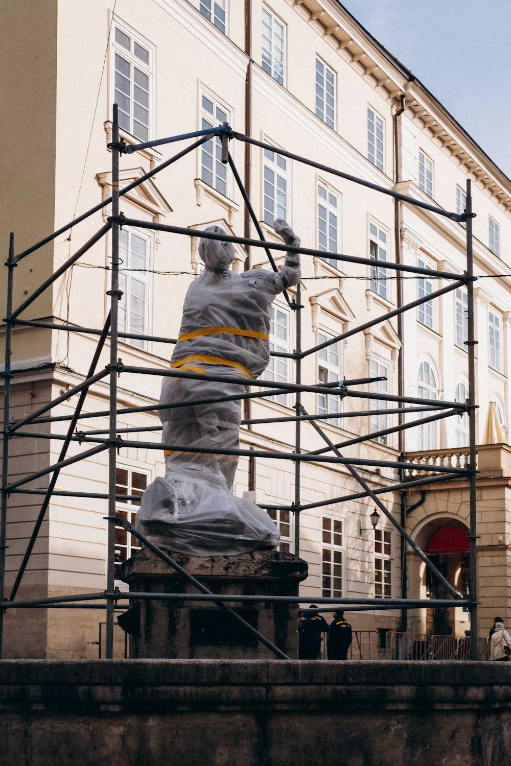 a statue of a man on a scaffold in front of a building