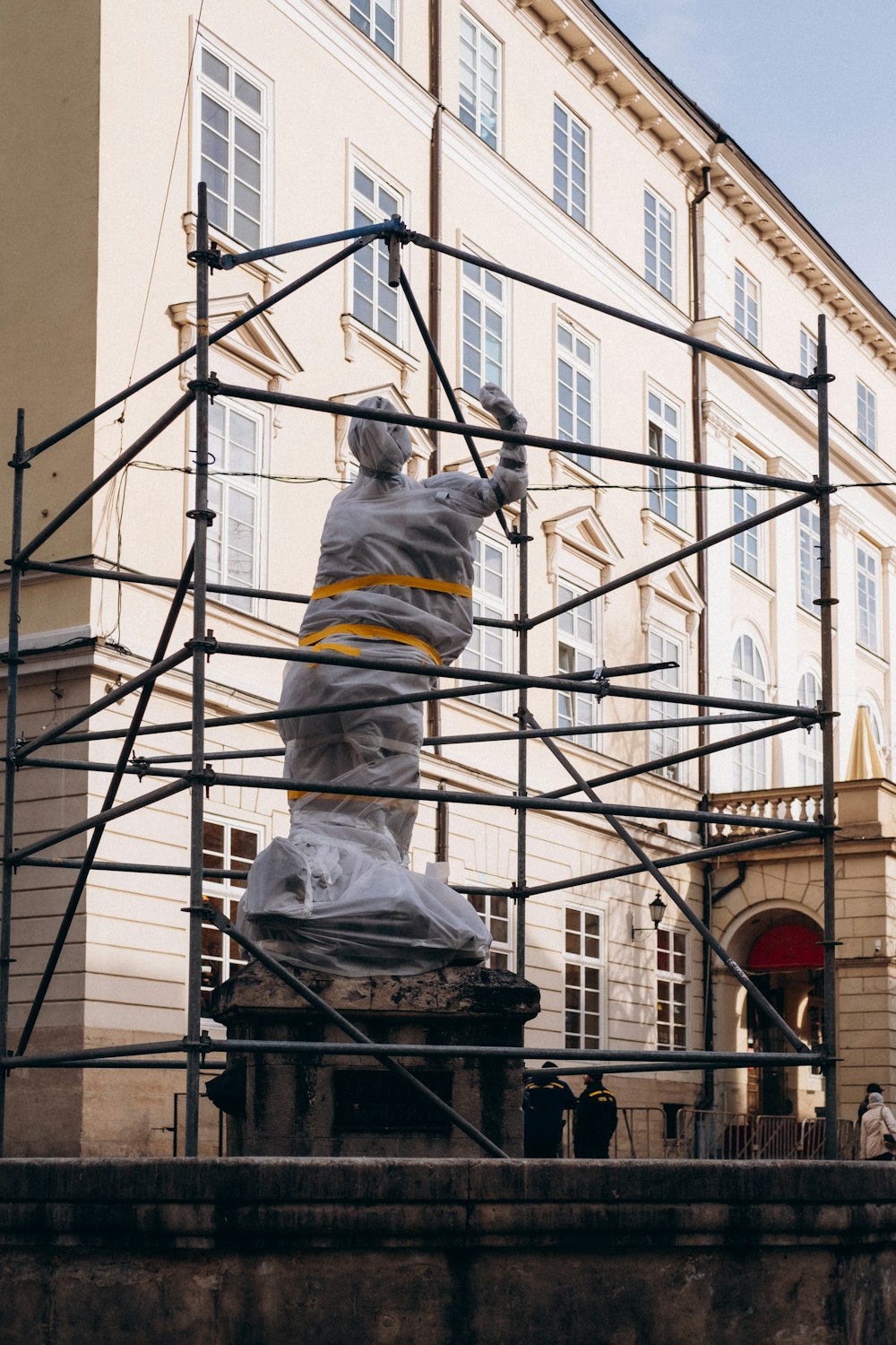 Eine Statue eines Mannes auf einem Gerüst vor einem Gebäude