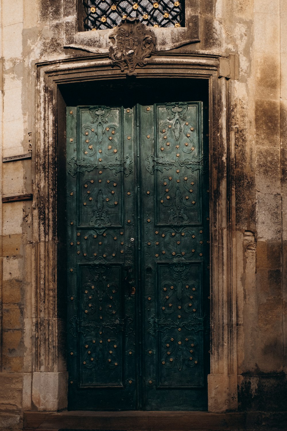 a large green door with a window above it