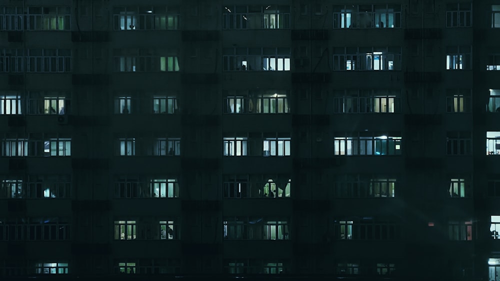 a tall building with lots of windows lit up at night