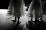 Elegant ballet dancers poised gracefully on a dimly lit stage.