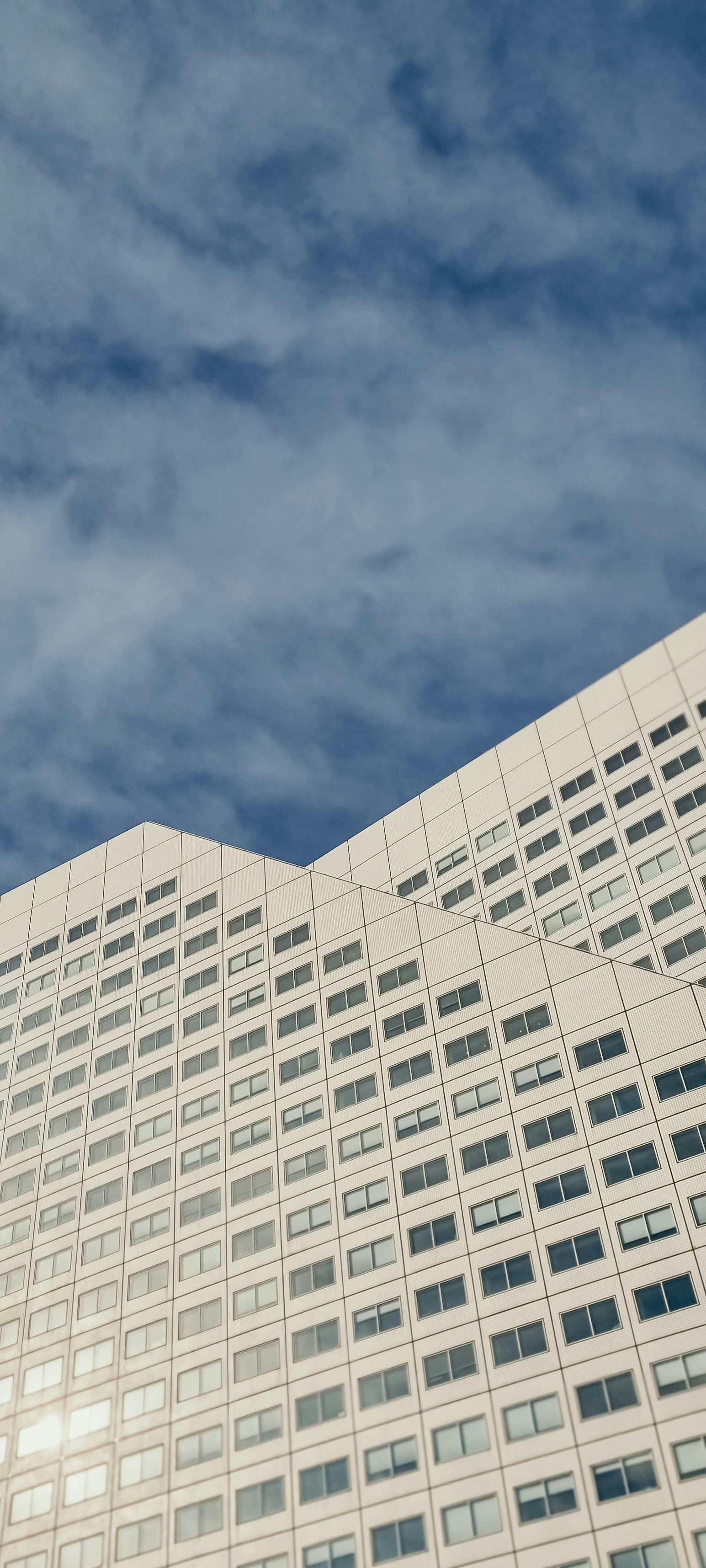 Un grand bâtiment blanc avec une horloge sur le côté