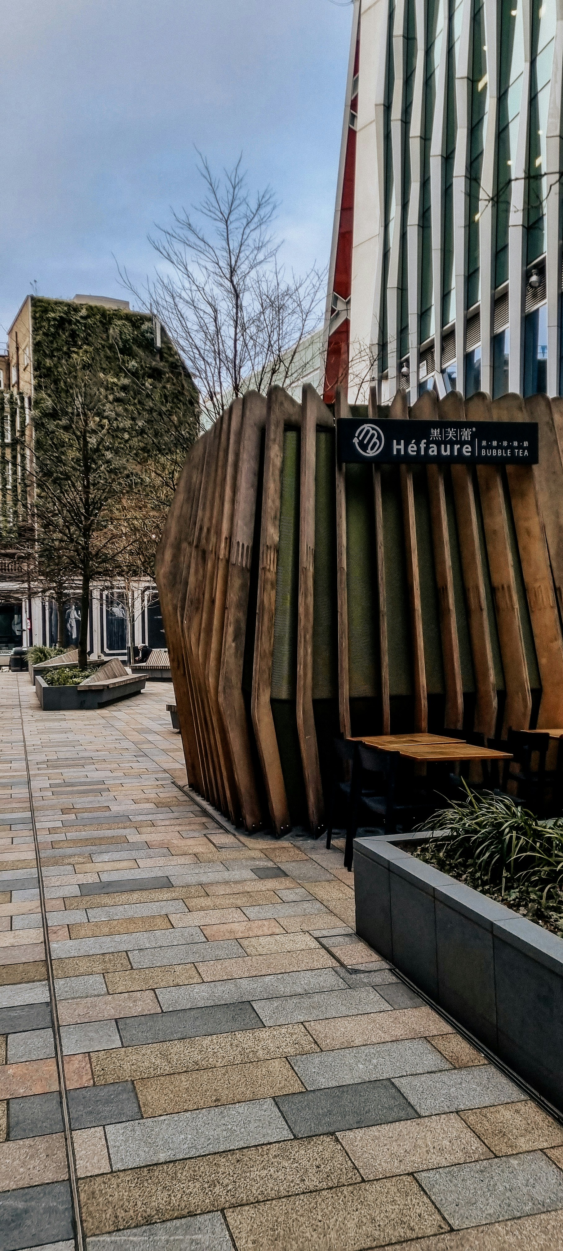 eine große Holzskulptur, die am Straßenrand sitzt