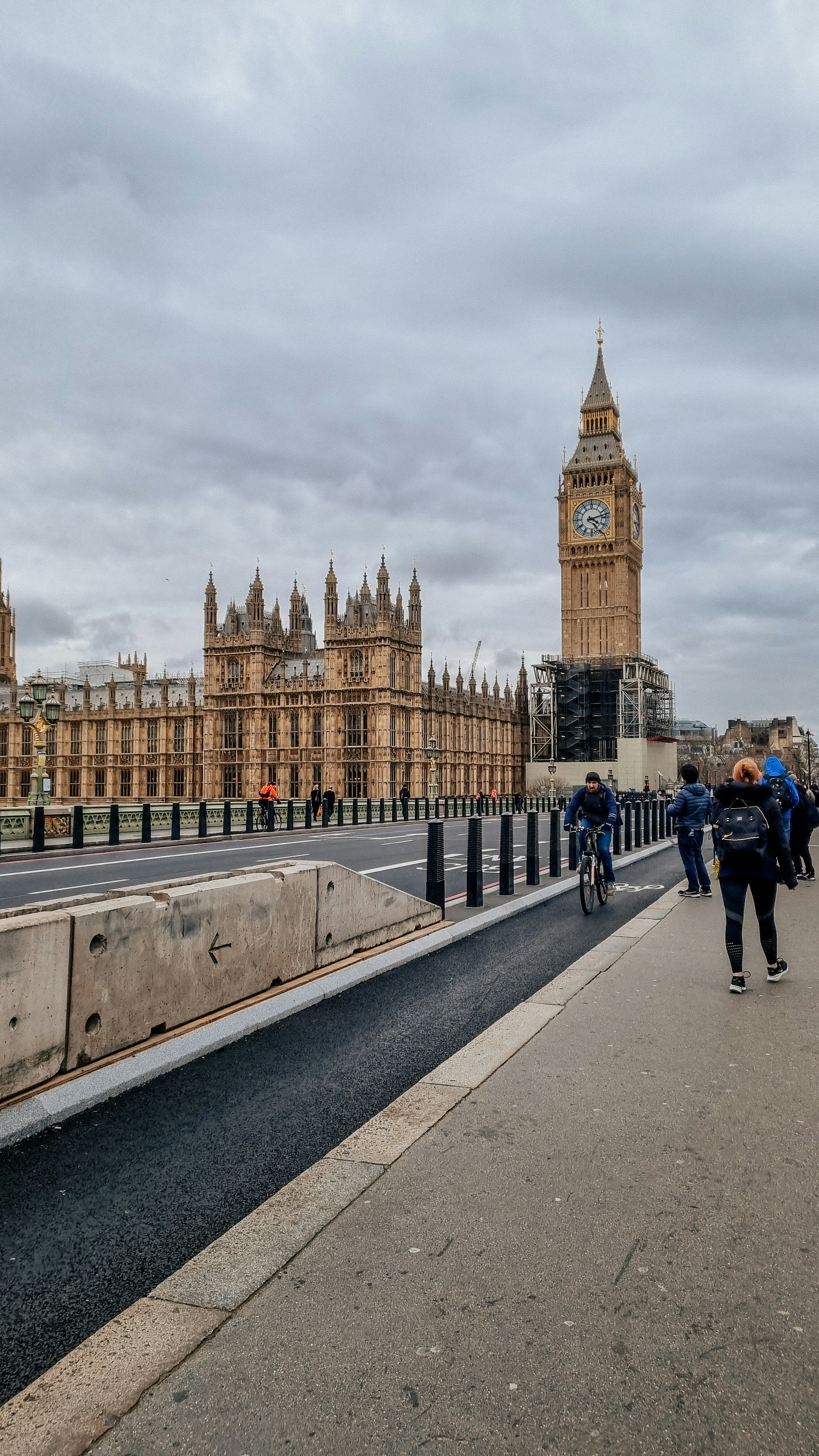 Eine Gruppe von Menschen, die eine Straße neben einem Glockenturm entlang gehen