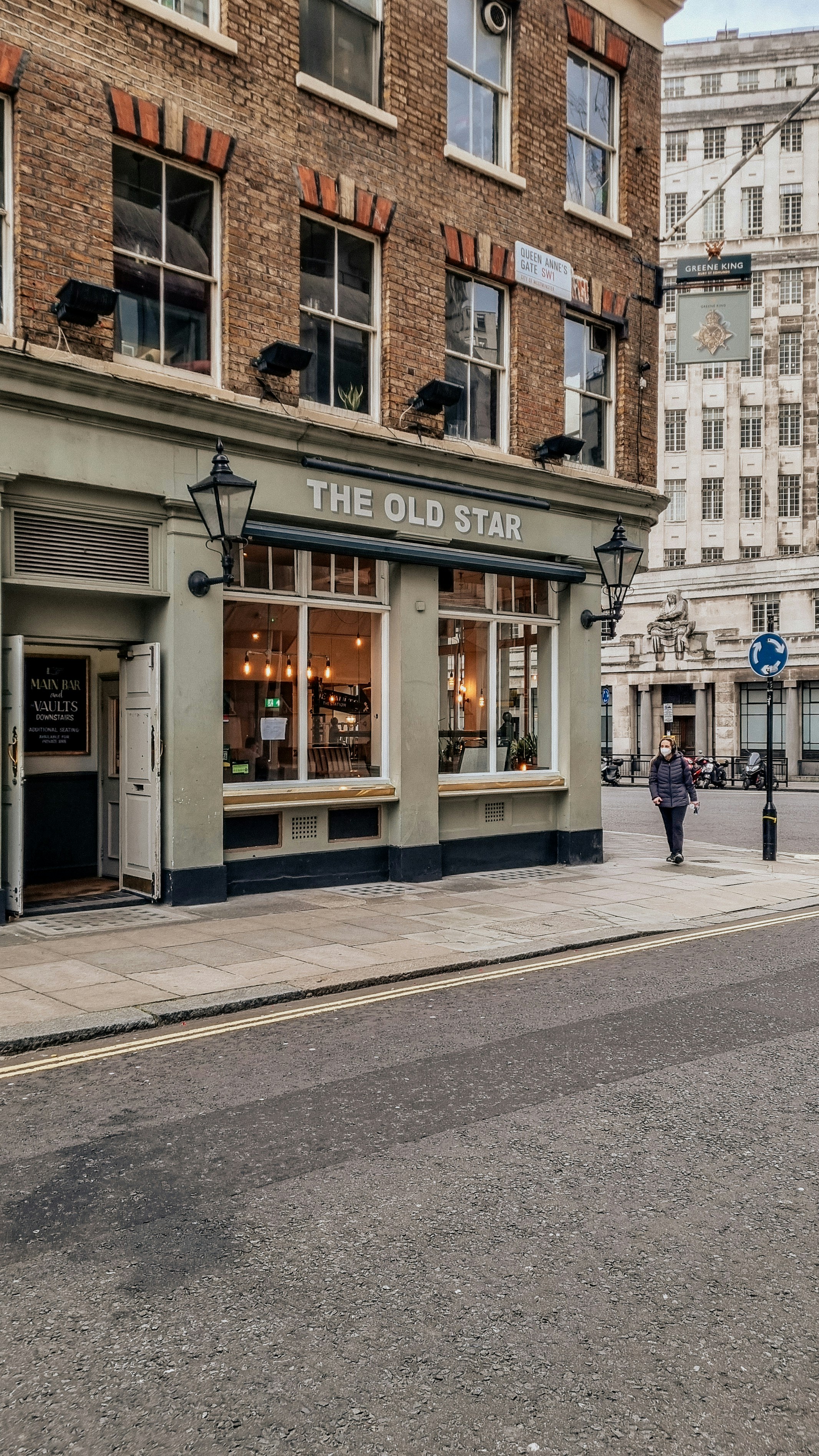 eine Straßenecke mit einem Gebäude und einer Person, die auf dem Bürgersteig geht
