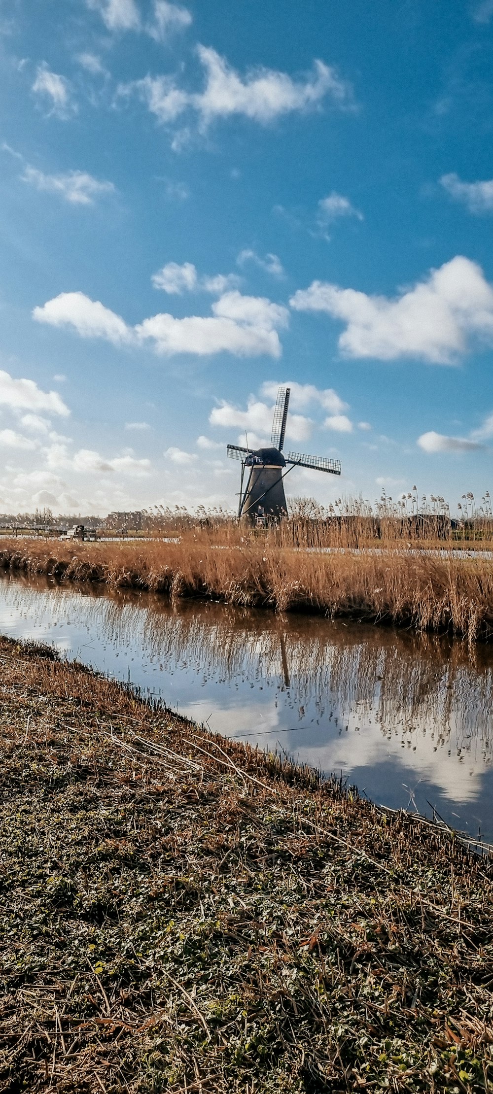 a windmill sitting on top of a dry grass field