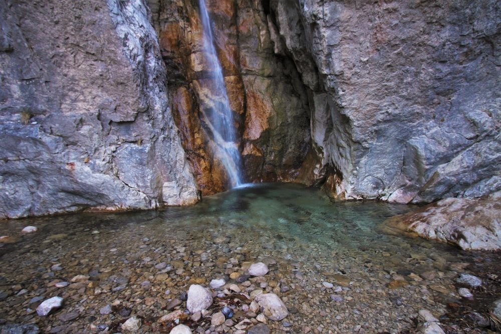 a small waterfall in the middle of a rocky area