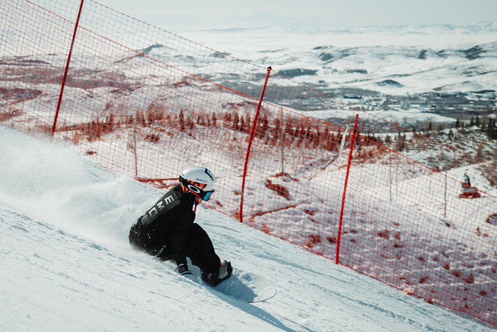 a man riding a snowboard down a snow covered slope