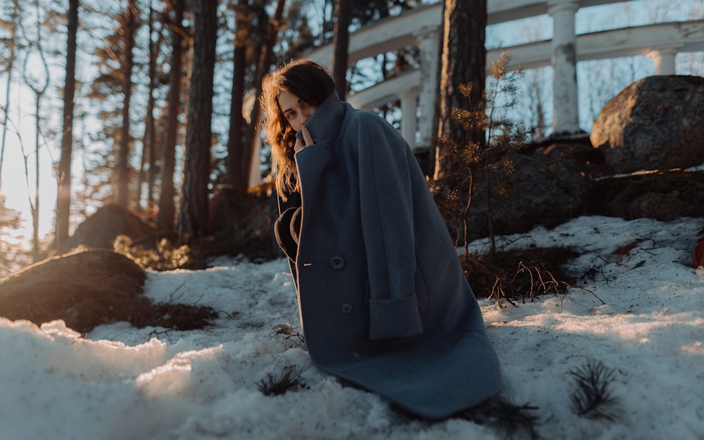 Eine Frau sitzt im Schnee und telefoniert mit einem Handy