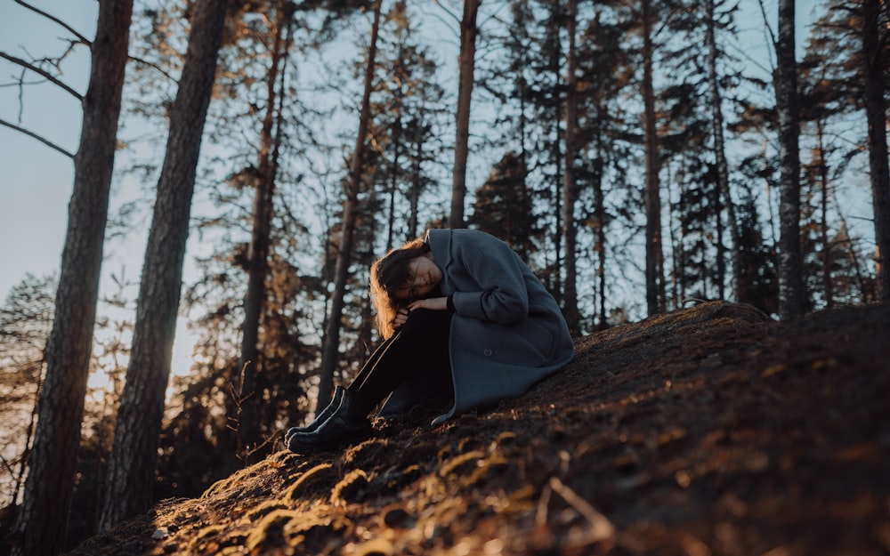 Una mujer sentada en una colina en el bosque