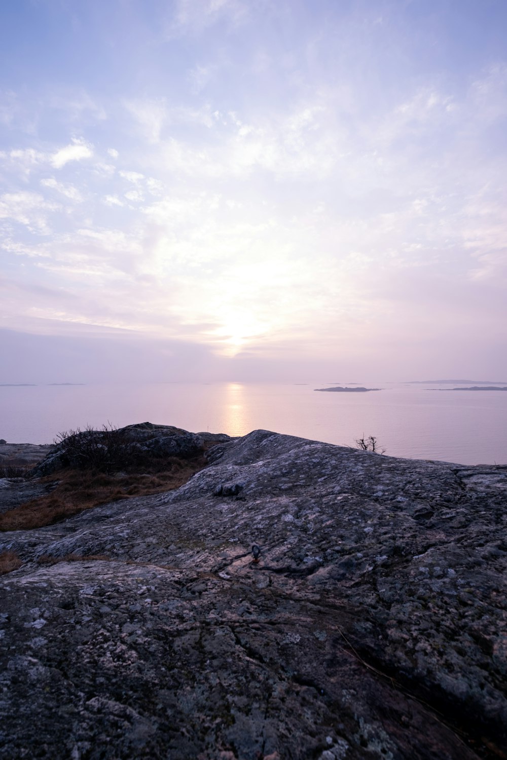 a bench sitting on top of a rocky hill next to a body of water