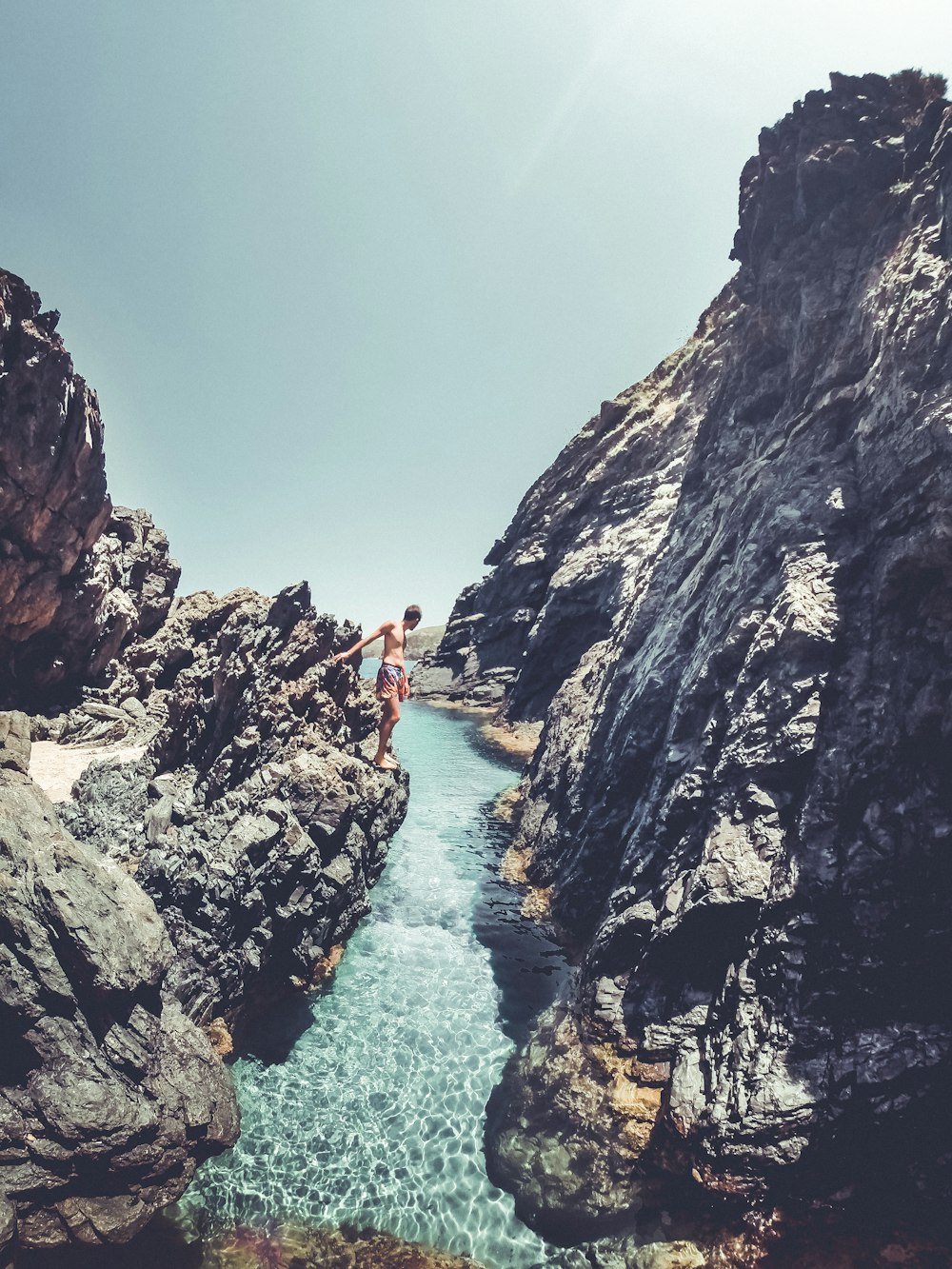 a person jumping off a cliff into a body of water