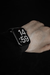 Close-up of hands adjusting a modern Urbancraft smartwatch on a runner’s wrist at dawn.