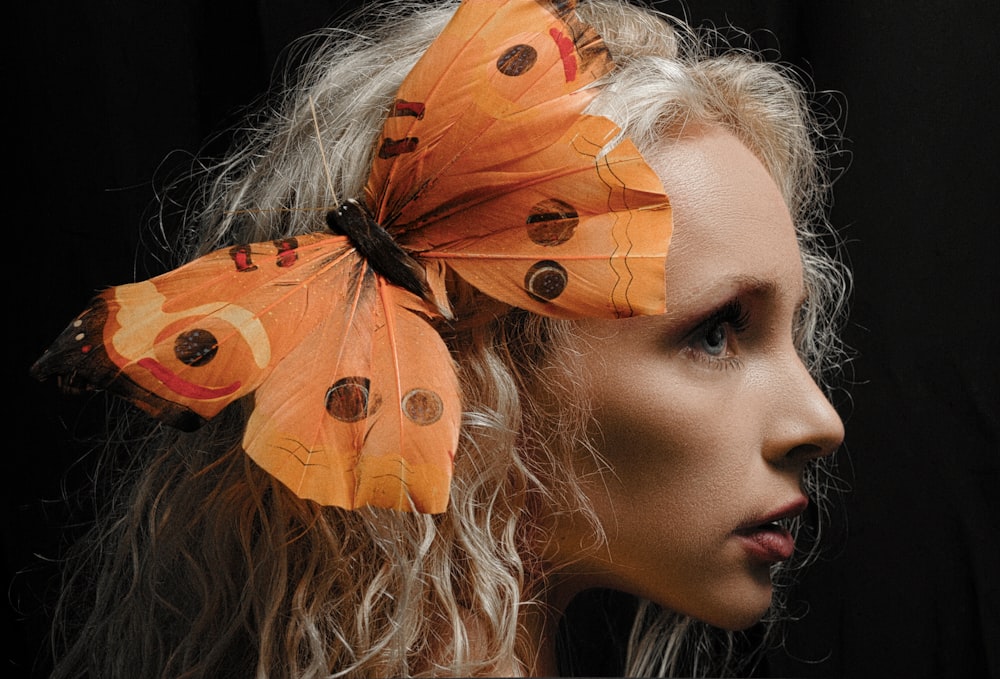 a close up of a woman with a butterfly on her head