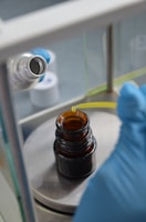 Close-up of a scientist pipetting a glowing blue solution in a sleek lab.