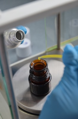 Close-up of a scientist pipetting vibrant blue liquid in a high-tech lab.