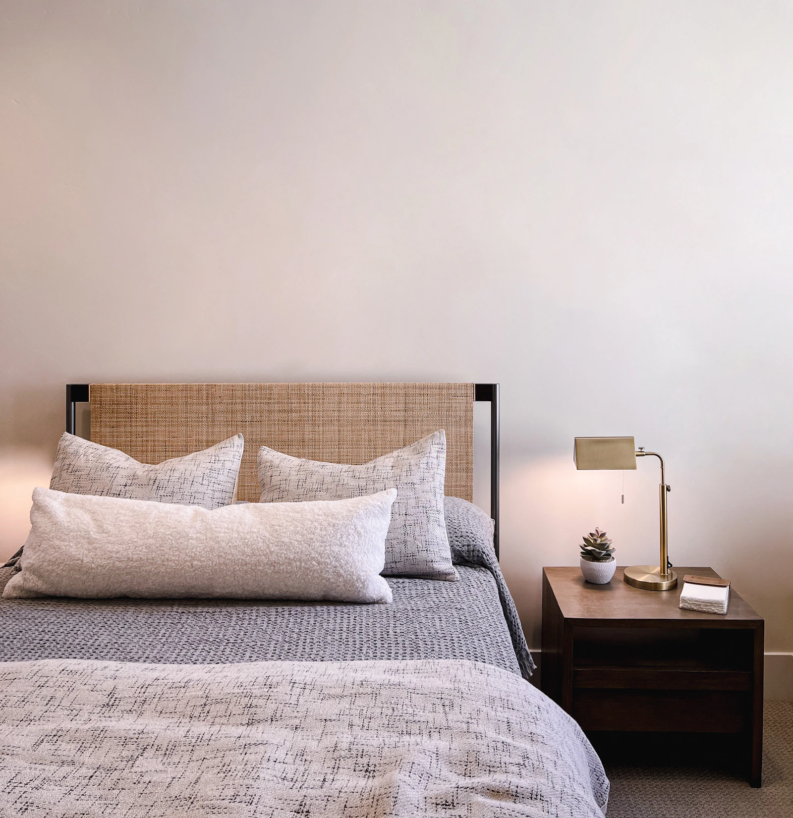 A calm bedroom with a nightstand and lamp beside the bed