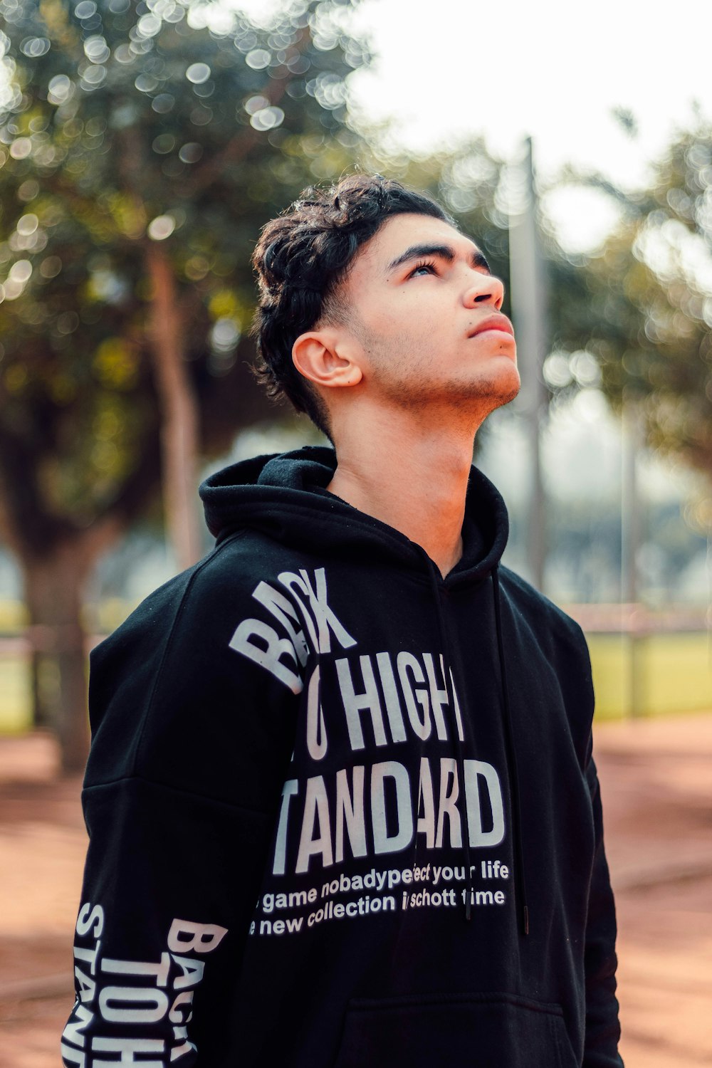 A man in a black hoodie looking up at the sky photo – Free Clothing Image  on Unsplash