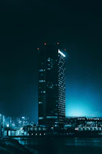 A serene city hall building bathed in blue and green light representing transparency and growth.