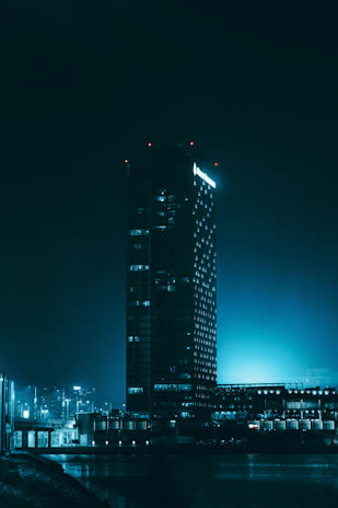 A serene city hall building bathed in blue and green light representing transparency and growth.