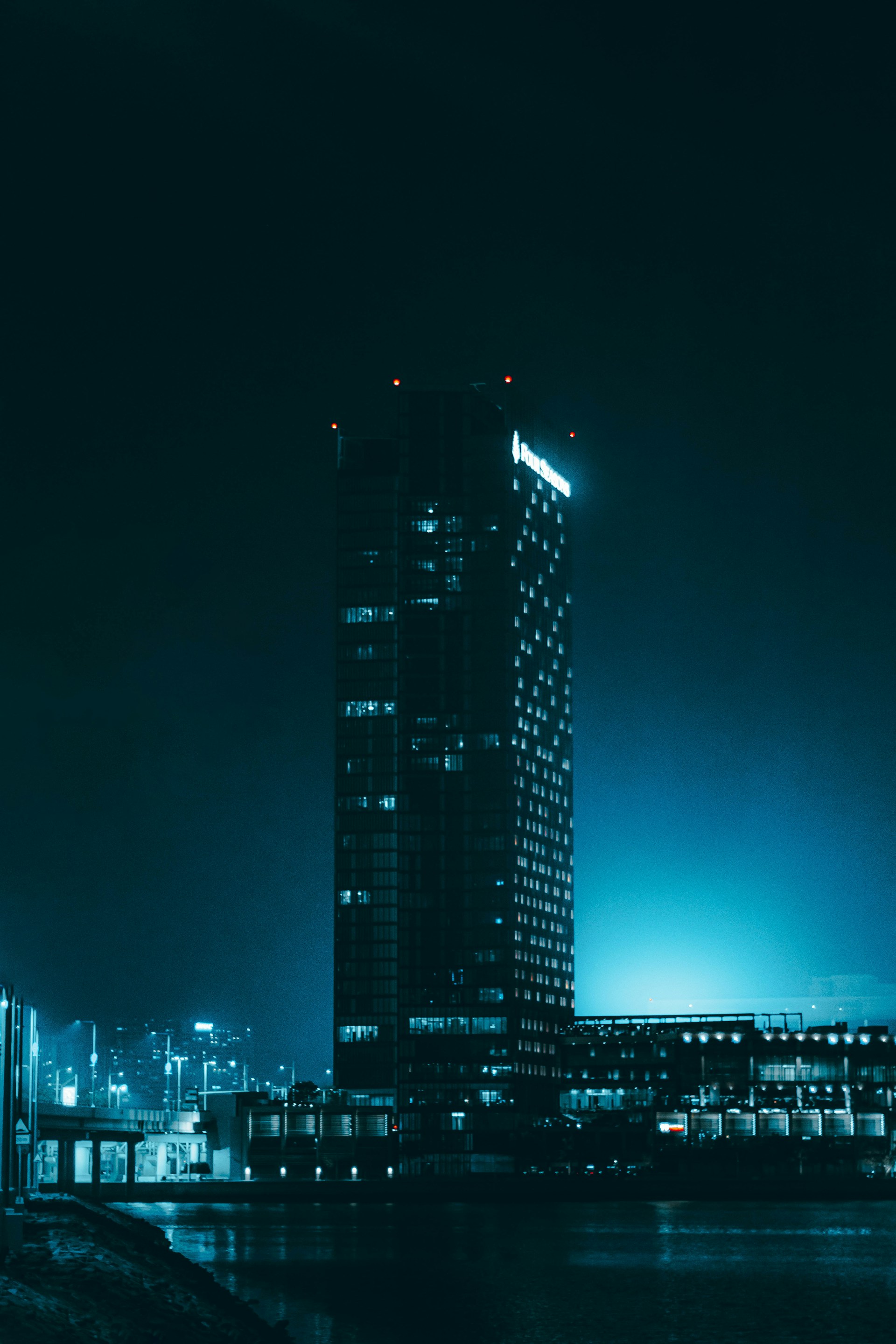 a very tall building sitting next to a body of water