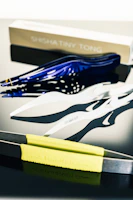 Set of various sized tongs neatly arranged on a rustic dining table ready for a barbecue.