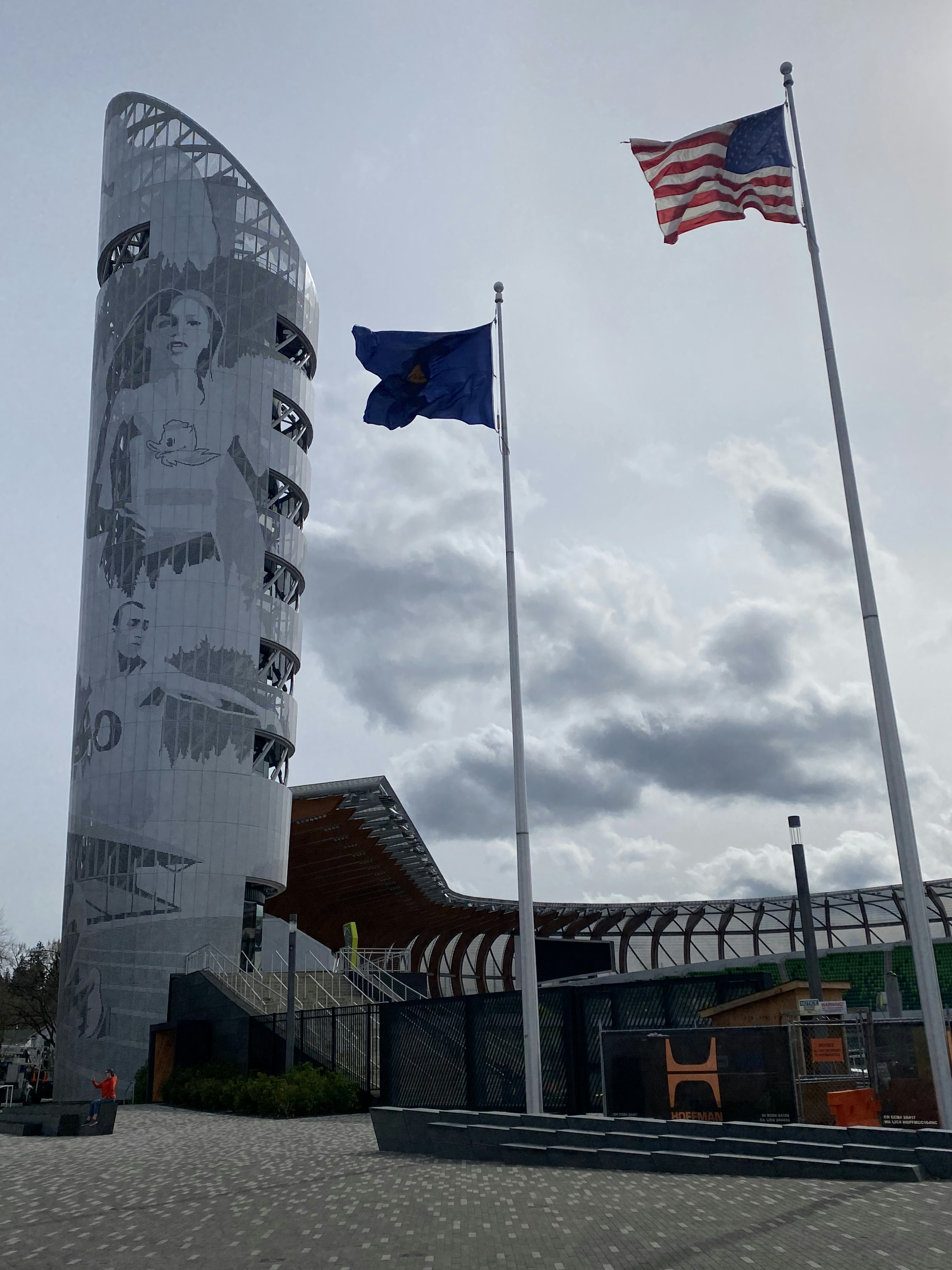 two flags flying in front of a tall building