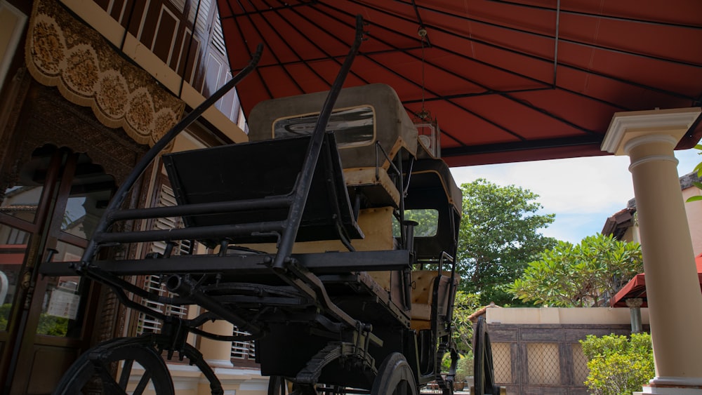 a horse drawn carriage parked under a red awning