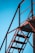 A metal structure framing the sky with stair-like features, characterized by industrial design with holes in the metal beams creating a patterned texture. The structure appears sturdy and functional, intersecting at various angles.
