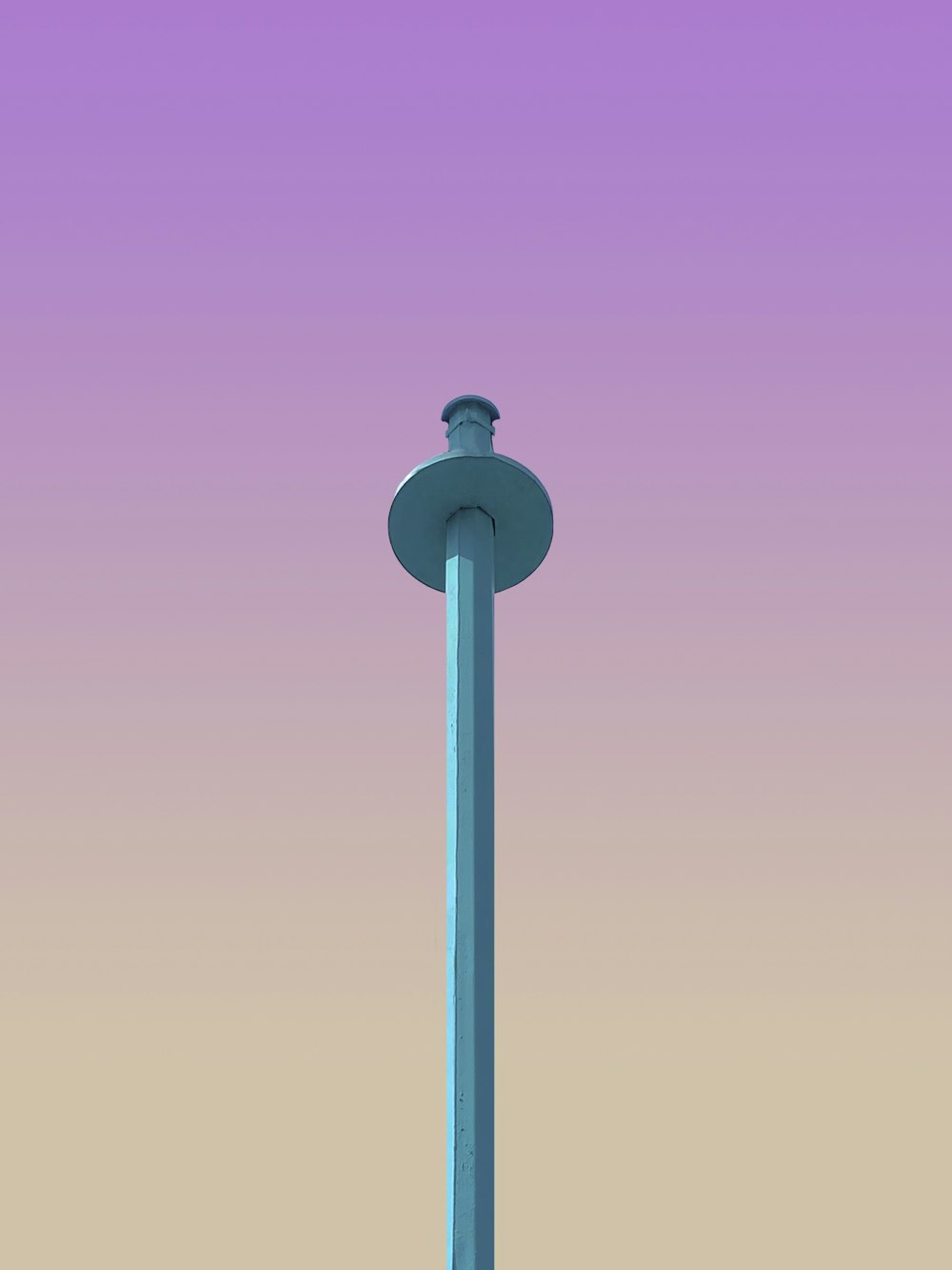 a tall light pole with a purple sky in the background