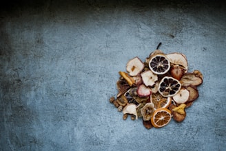 Close-up of vibrant dried fruit slices arranged on rustic wooden table with natural light.
