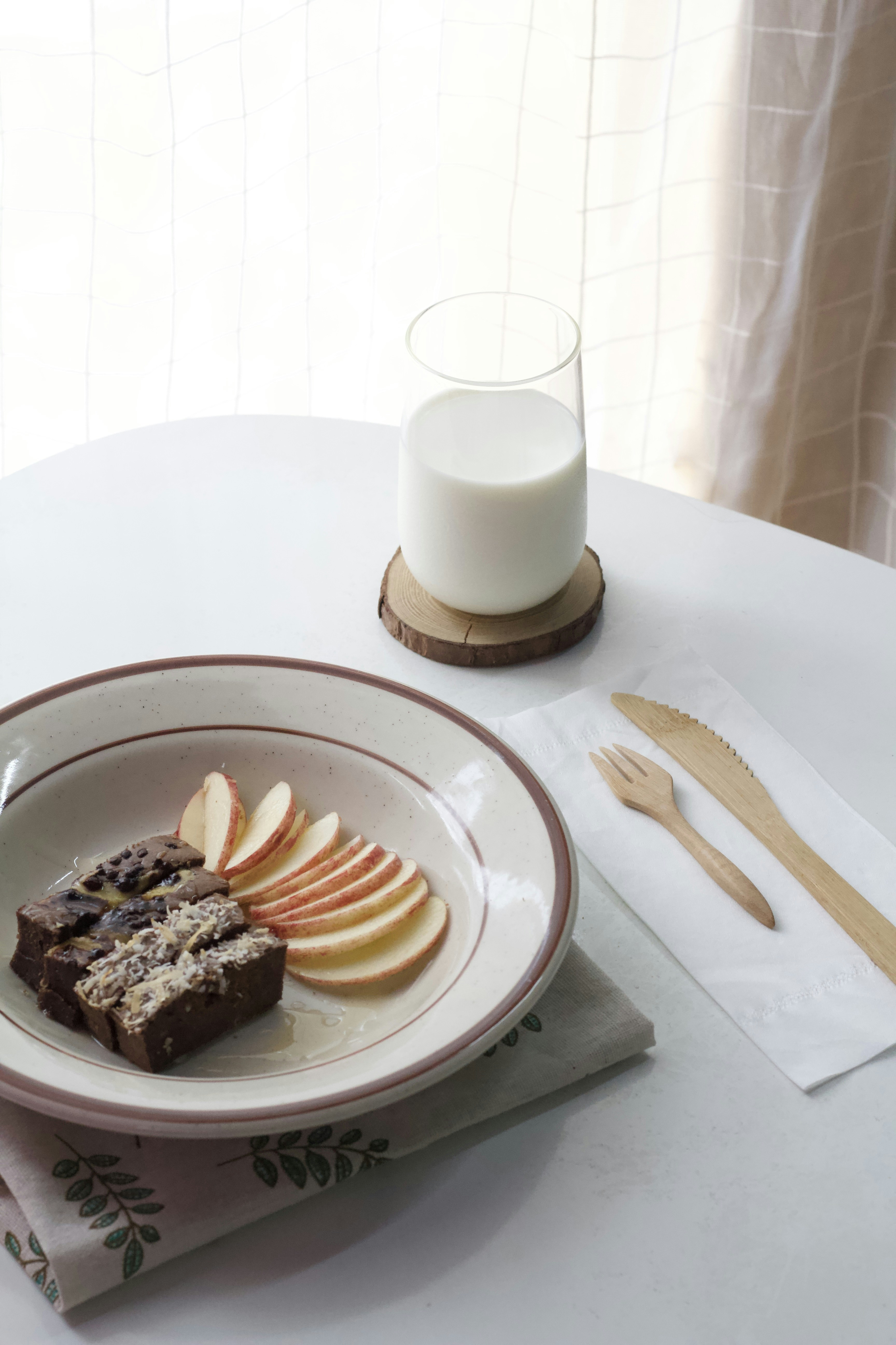 a plate of food on a table next to a glass of milk