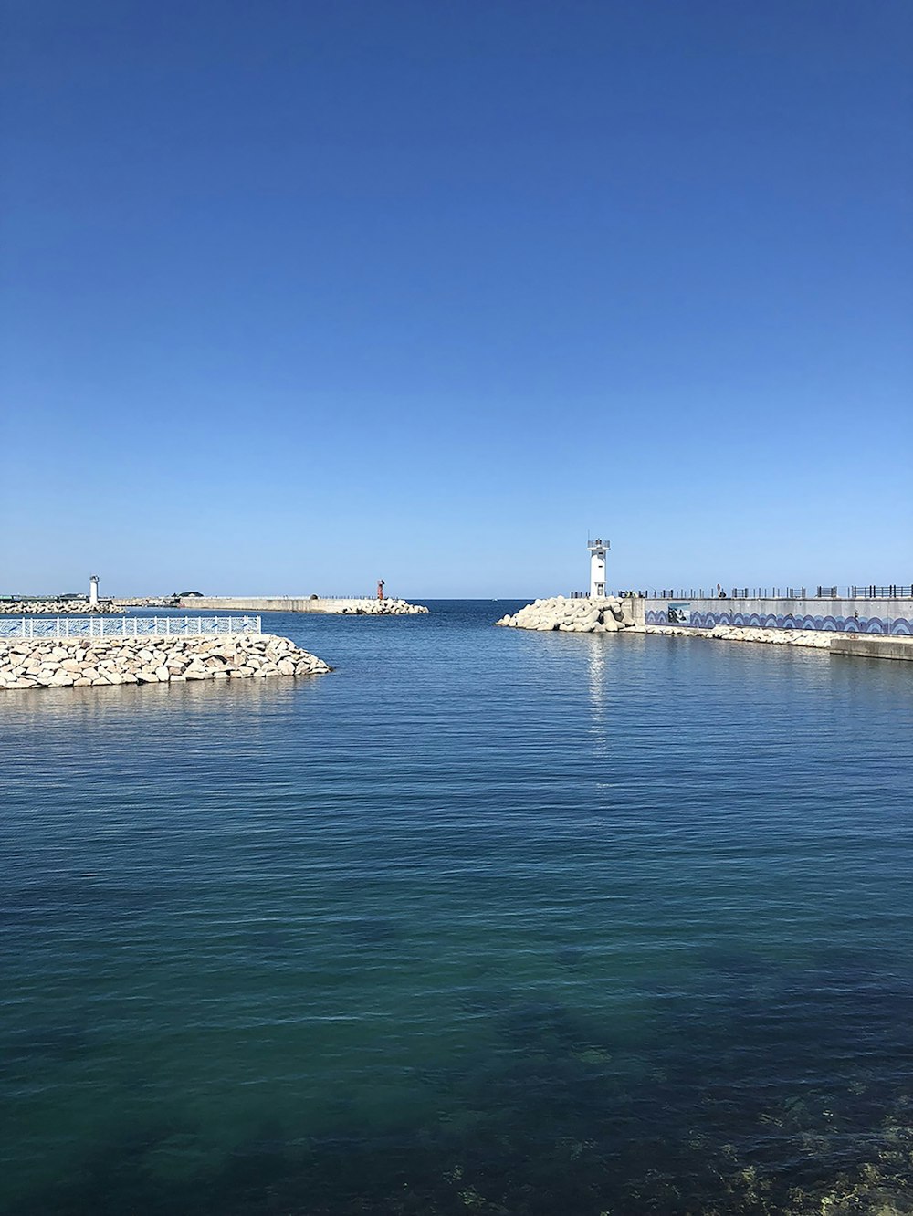 a body of water with a light house in the distance