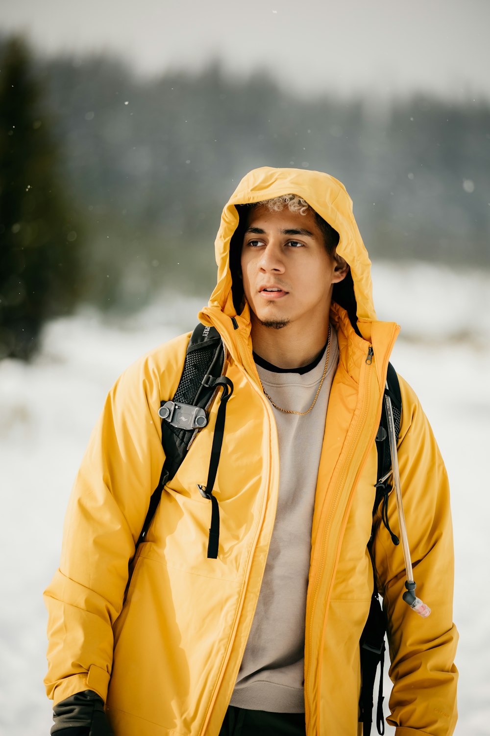 a man in a yellow jacket standing in the snow