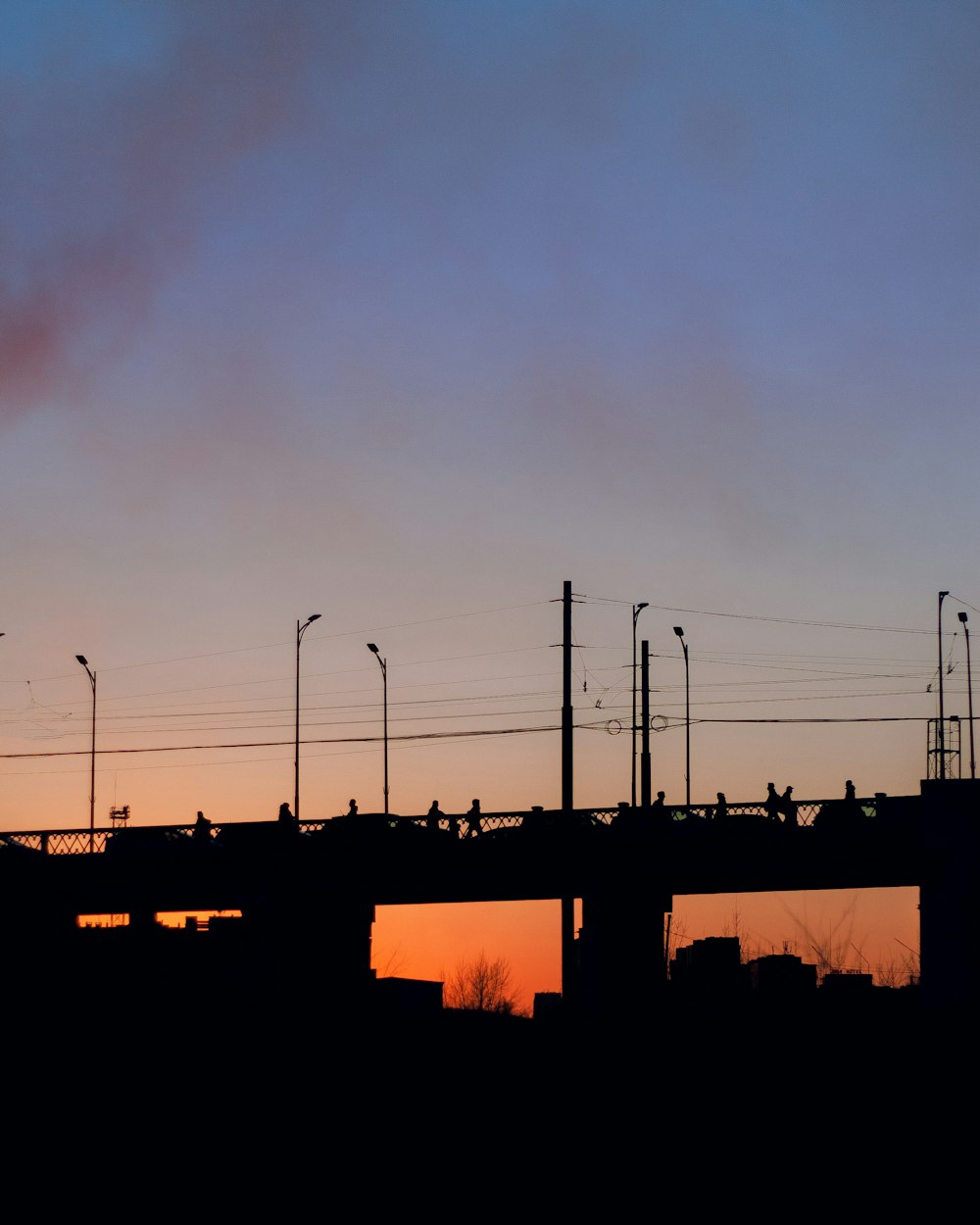 a train traveling over a bridge at sunset