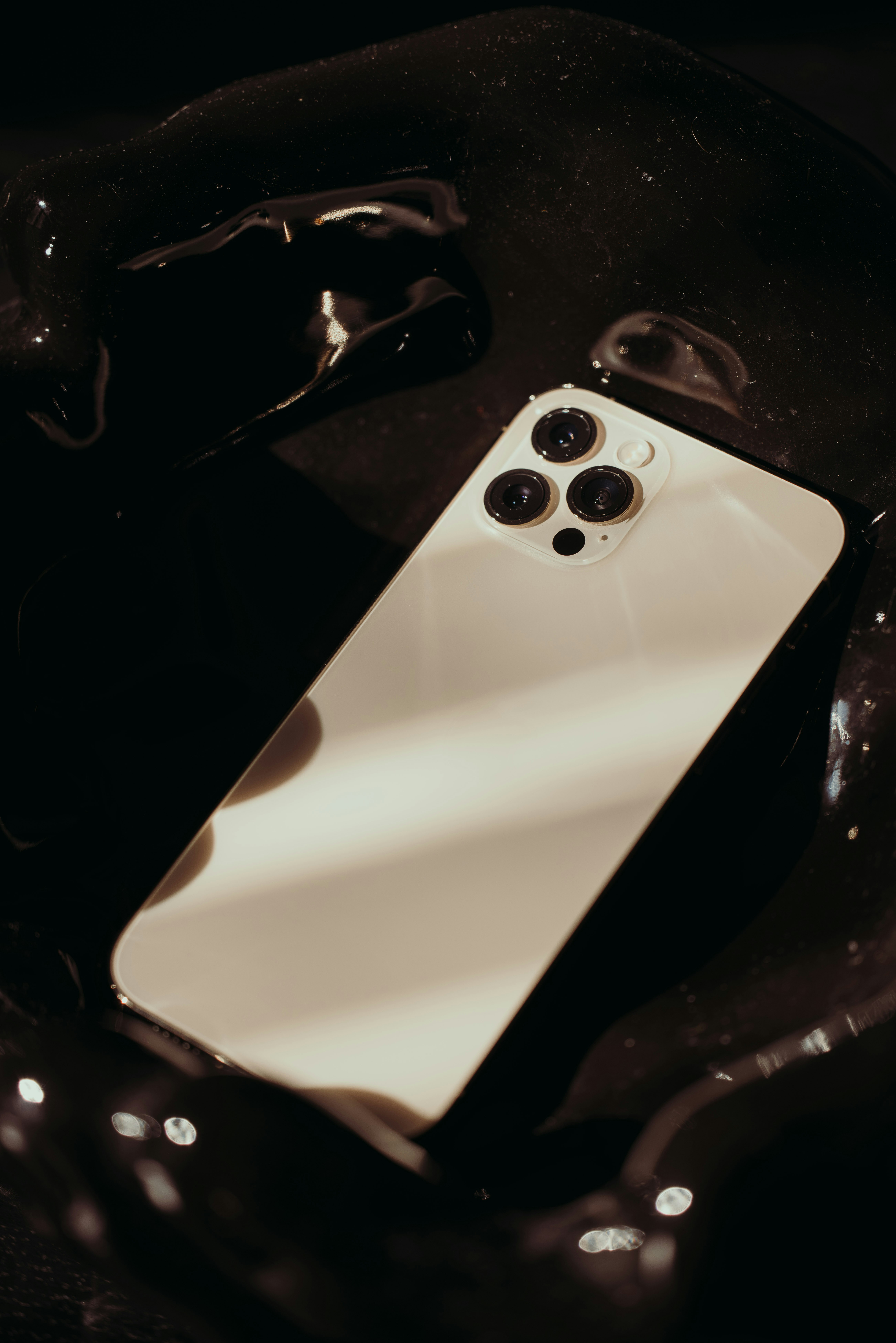 a white cell phone sitting on top of a black table