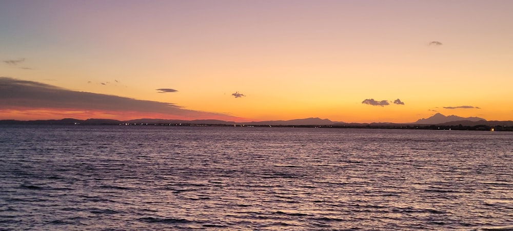 the sun is setting over a body of water