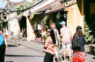 A warm photo of the author walking through a lively street in Magé, smiling and engaging with locals.