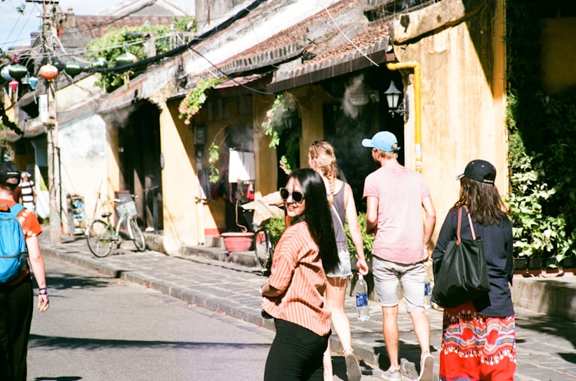 A candid shot of a sunlit street bustling with locals sharing stories and laughter.