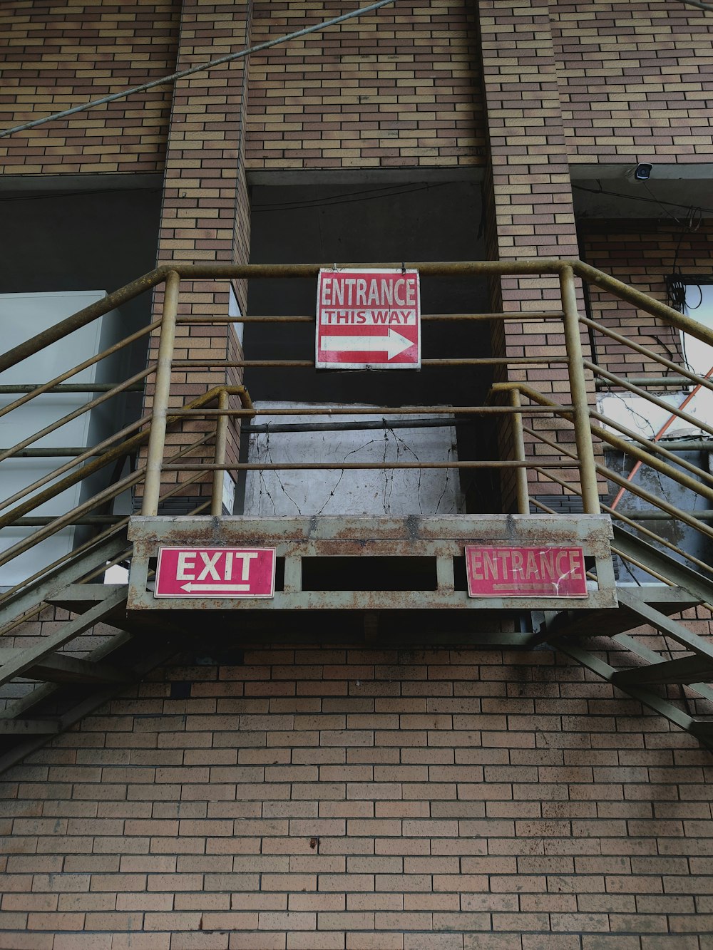 two red and white signs on a brick building